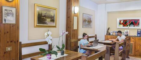A wooden interior with benches, a table, and a laptop.
