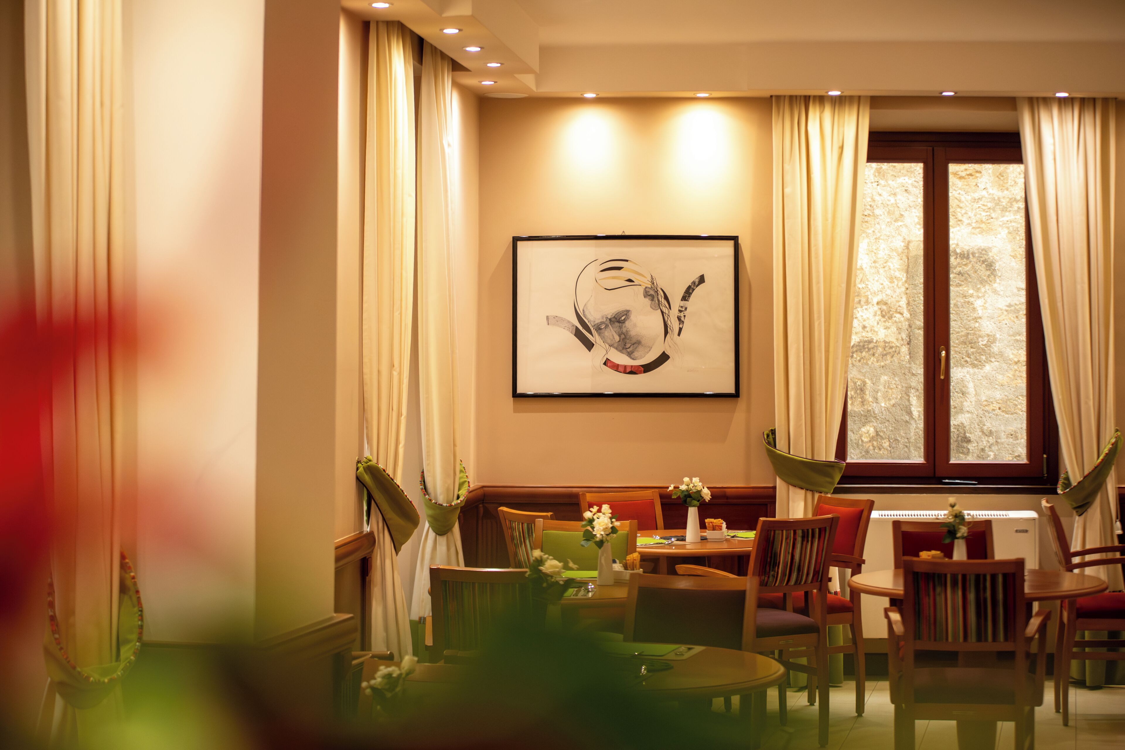Comedor con mesa, sillas y ventana con cortinas.