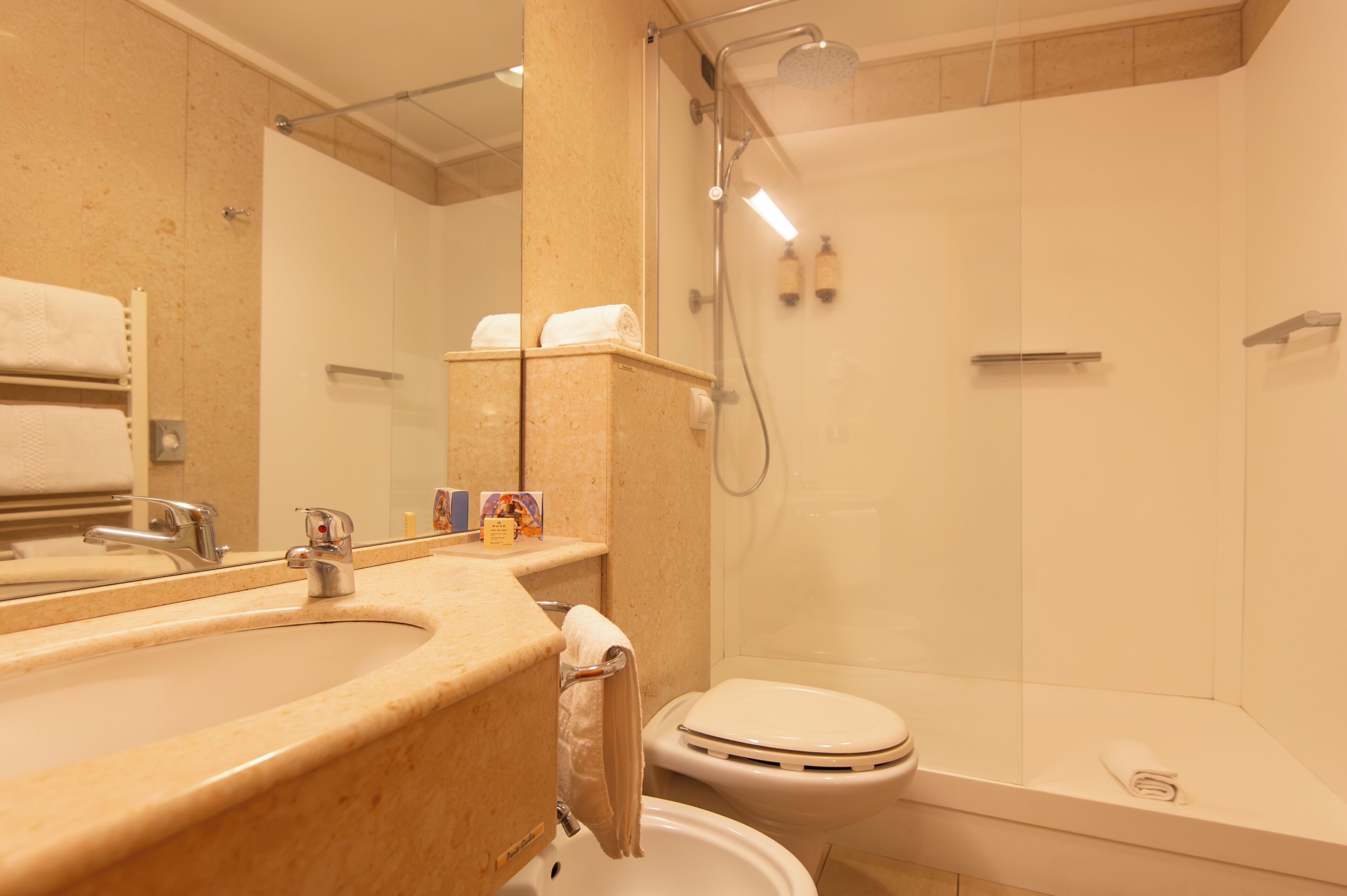 Baño con lavamanos, inodoro y ducha.