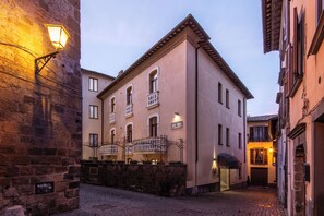 Un edificio histórico con fachada de piedra, entrada porticada y un cartel que indica 'Hotel D'Or'.