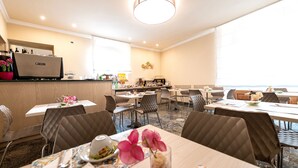A hotel dining area with tables set for service, a bar area, and a view of the ocean. - Hotel Corso (Orvieto)