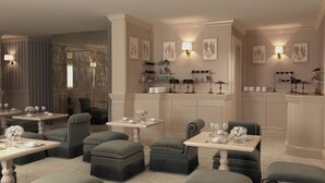 A dining area with multiple tables and cushioned seating, a kitchen area with shelves, and decorative wall art. - Hotel Bartolomeo (Venice)