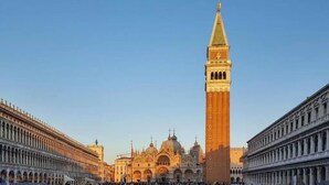 A historic square with a prominent clock tower, a cathedral, and classical architecture. - Hotel Bartolomeo (Venice)