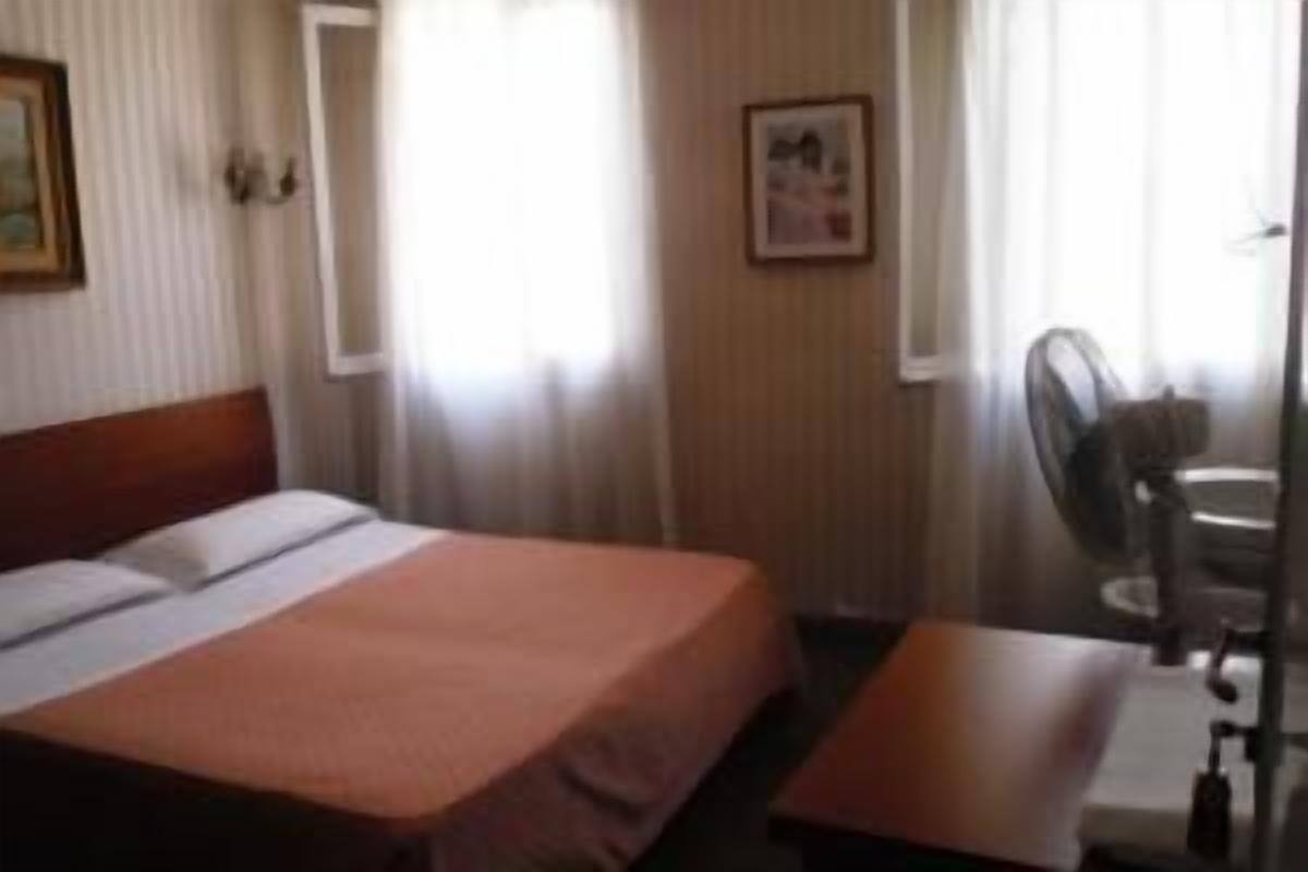 A hotel room with a bed, a desk, and a chair.