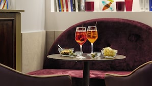 A table with two drinks, a bowl of olives, and a bowl of chips. - Hotel Al Nuovo Teson (Venice)