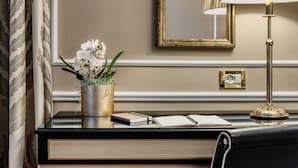 A desk with a vase of white orchids, a lamp, and books. - Hotel Al Nuovo Teson (Venice)