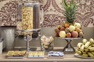 Un buffet con diverse opzioni alimentari, tra cui cereali, frutta e snack confezionati.