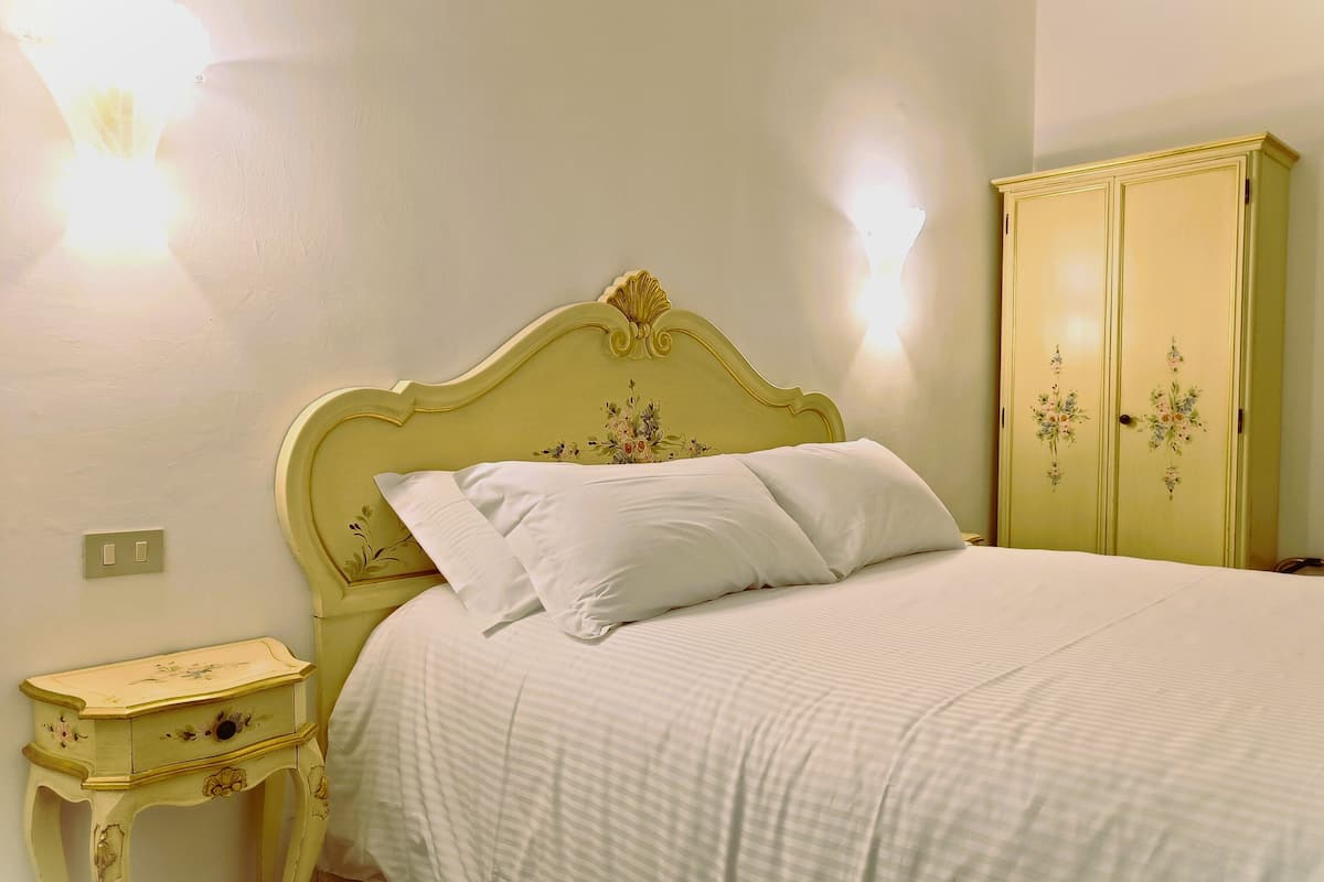 Una camera da letto con un letto, un comodino e un armadio.