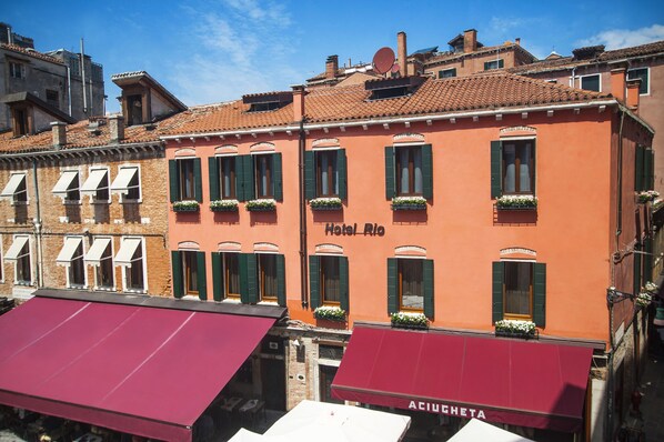A building with a sign reading "Hotel Rio" and a red awning with "ACQUA GHETA" written on it. - Rio Hotel (Venice)