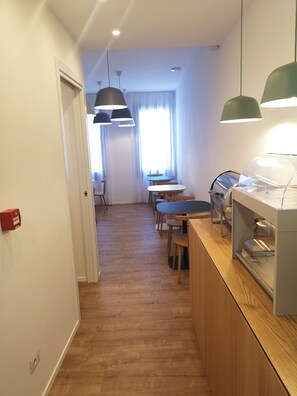 A modern kitchen with wooden flooring, a dining area with a table and chairs, and pendant lighting. - Rio Hotel (Venice)