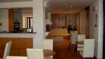 A hotel lobby with a reception desk, seating area, and a sofa.