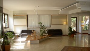 A spacious living room with a wooden coffee table, a sofa, and two potted plants. - Umbria (Attigliano)