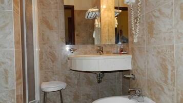 A bathroom with a sink, mirror, and a towel rack.