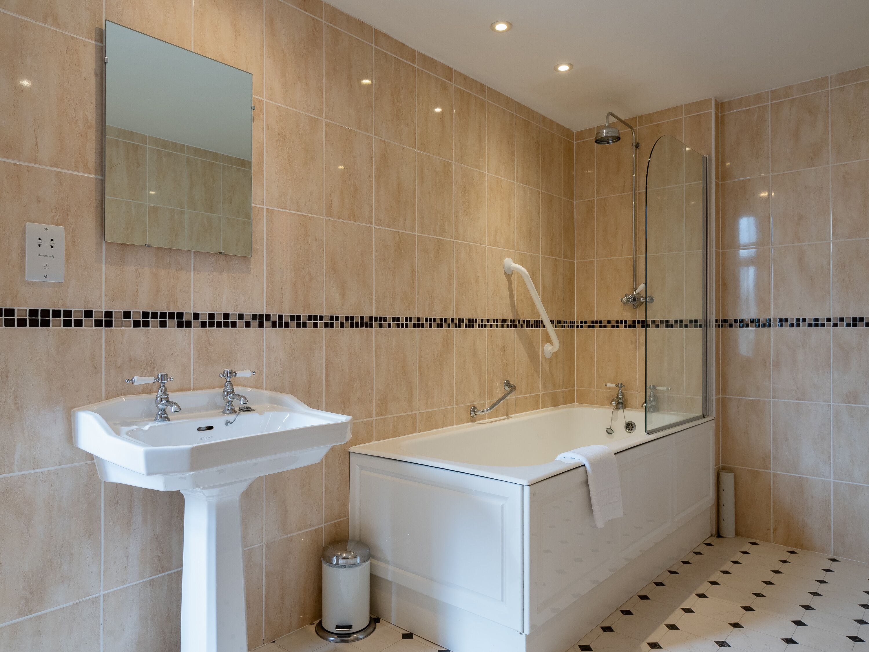 A modern bathroom with a sink, bathtub, and shower.