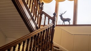 Una imponente escalera con ornamentación elaborada y un candelabro.