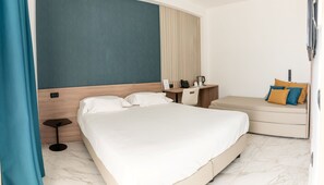 Standaard driepersoonskamer | Een minibar, een kluis op de kamer, een bureau, geluiddichte muren