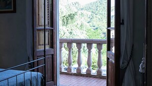 A room with a balcony overlooking a mountainous landscape. - Villa Rosa Panzano (Greve in Chianti)