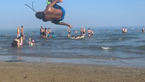 A beach scene with people swimming and surfing. - Hotel Maxim (Caorle)
