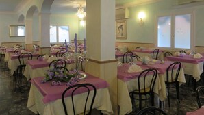 A dining area with tables set for service, featuring a consistent layout with chairs and table settings. - Hotel Maxim (Caorle)