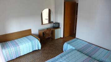 A hotel room with two beds, a desk, a chair, a television, and a wardrobe.