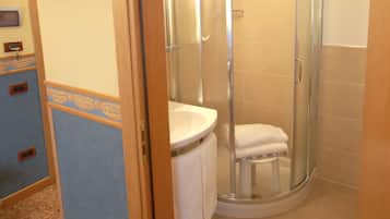 A bathroom with a shower, toilet, and sink.