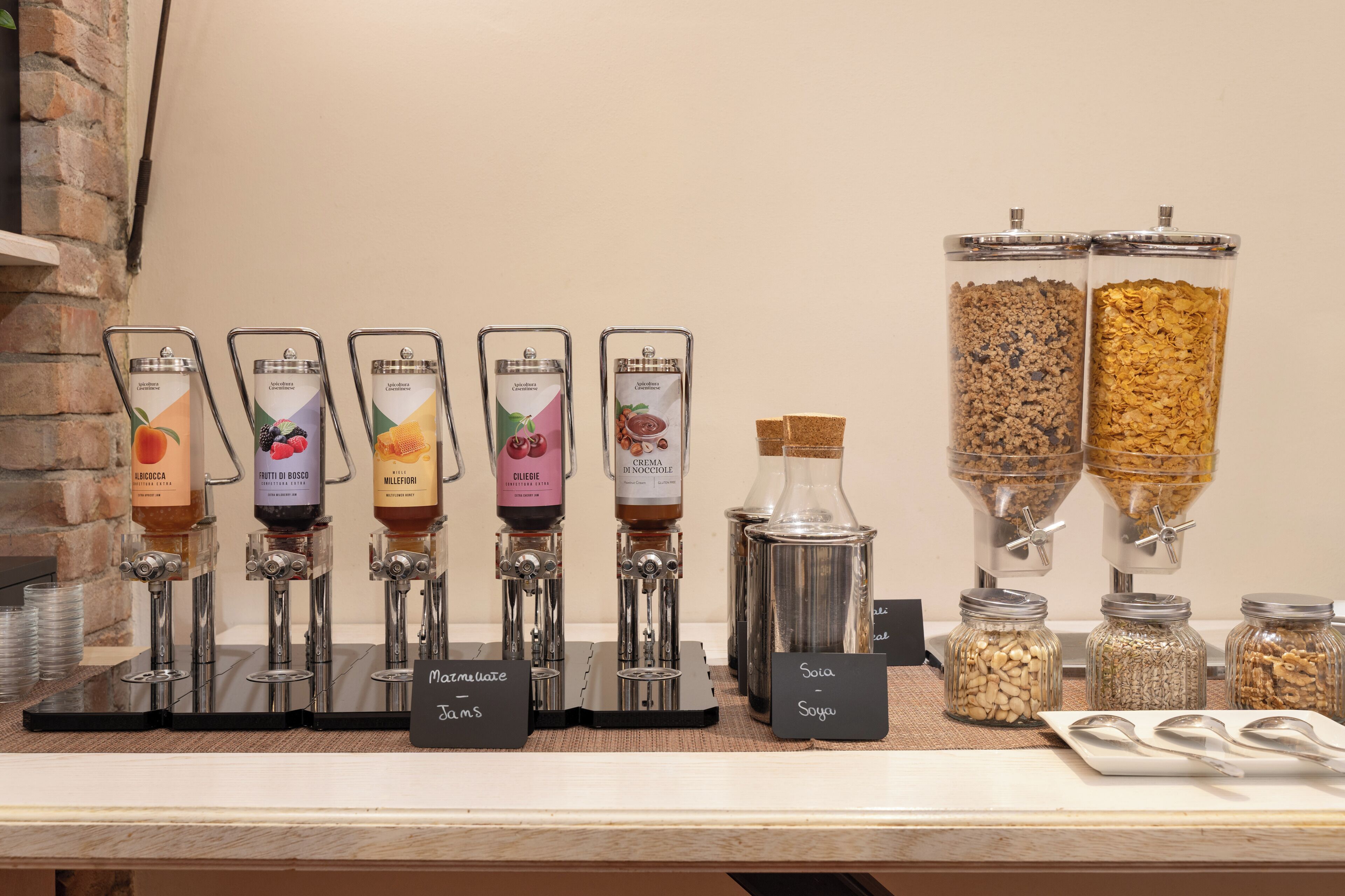 A beverage dispenser with various drink options and a selection of granola and nuts.