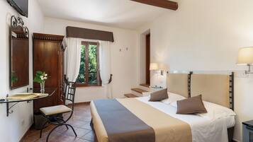 Quarto com cama, abajures, escrivaninha com cadeira, espelho e janela com cortinas.