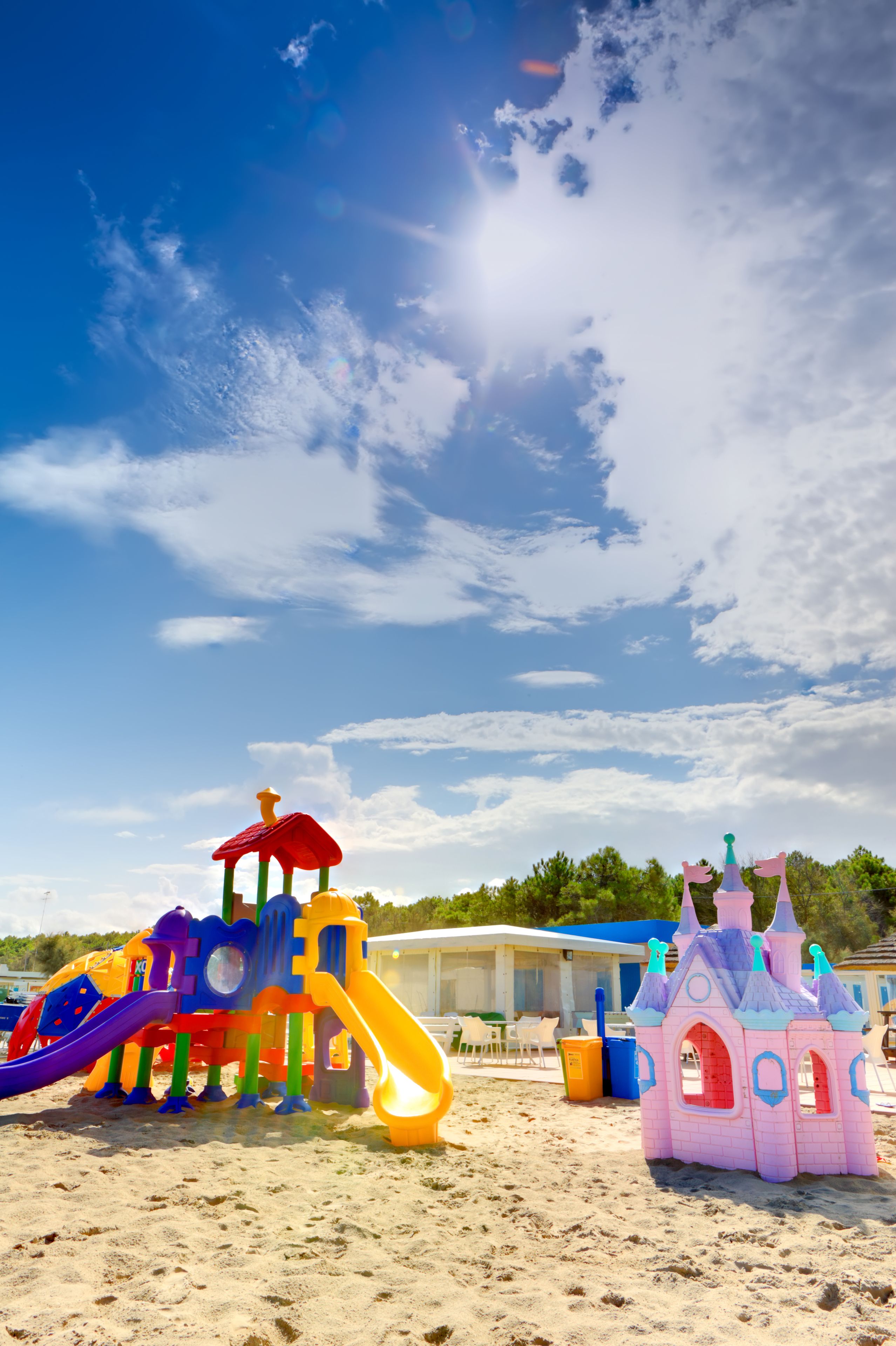 A beach with colorful play structures and a castle.
