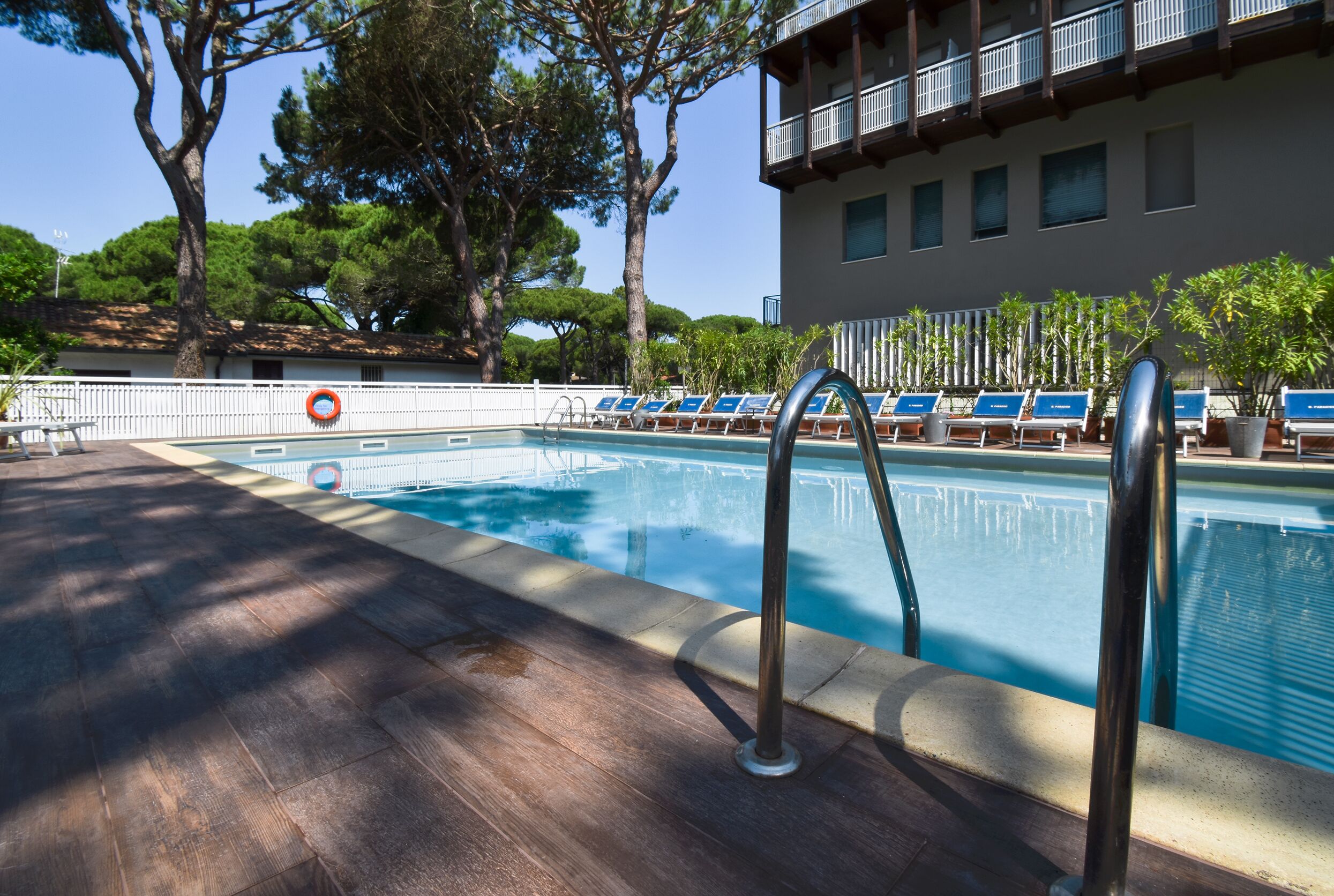 Una piscina con sillas de descanso y una terraza de madera.