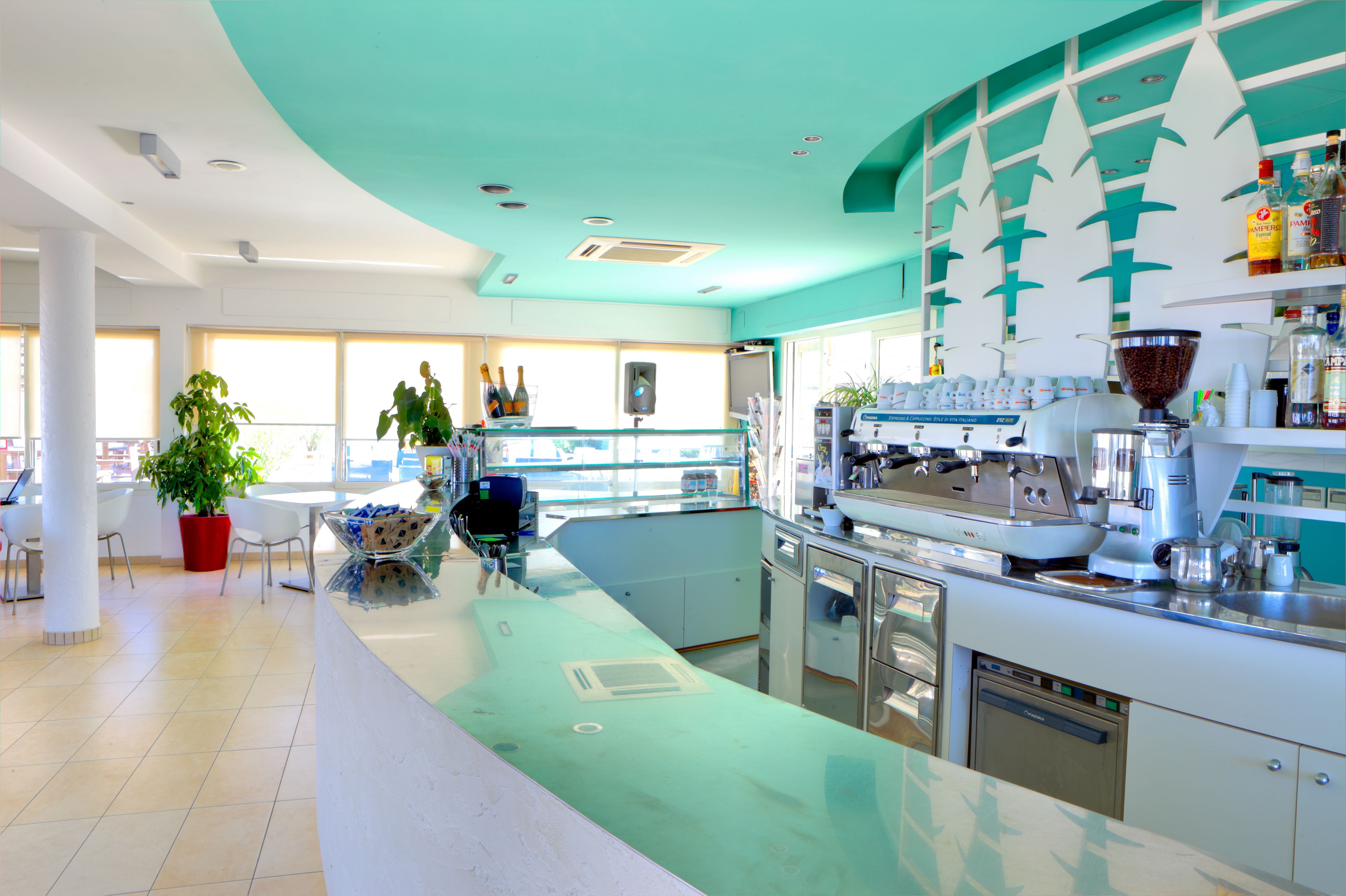 Un espace bar moderne doté d’un comptoir, de sièges et d’une machine à café.