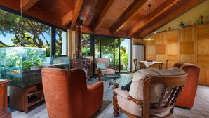 A spacious living area with wooden furniture, a glass fish tank, and a view of the outdoors. - Columbia (Ravenna)