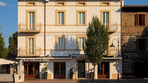 En toetagers bygning med et skilt, der siger "TRATTORIA da Elide" og "HOTEL", der angiver restaurant og hotel.