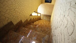 A staircase with a textured wall and a framed picture on the upper landing. - Hotel Casanova (Naples)