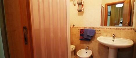 A bathroom with a toilet, bidet, and sink.