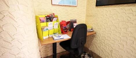 A small office space with a wooden desk, a black office chair, and a yellow filing cabinet.