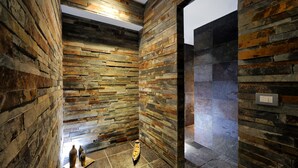 A modern bathroom with a stone wall design and a tiled floor. - Hotel Life (Rimini)