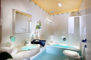 Ein Badezimmer mit Waschbecken, Spiegel, Badewanne und Toilette.