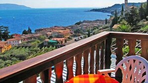 A balcony with a view of the sea and a town. - Palazzina (Gargnano)