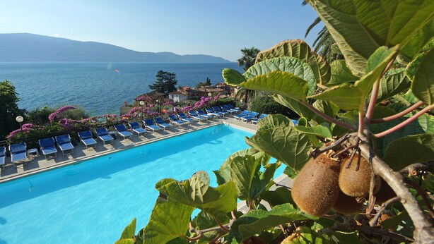 A pool with lounge chairs and a view of the sea. - Palazzina (Gargnano)