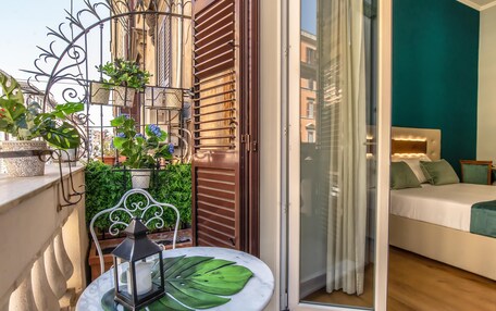 A balcony with a table, plants, and a lantern.