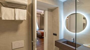 Un baño moderno con un espejo grande, un lavabo y un perchero para toallas.
