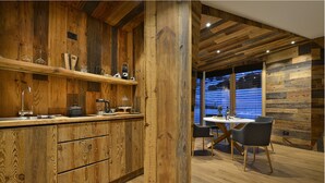Une cuisine rustique avec des meubles en bois et un coin repas comprenant une table et des chaises.
