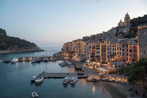 Un pueblo costero con edificios históricos, un puerto deportivo con barcos y una imponente torre de iglesia.
