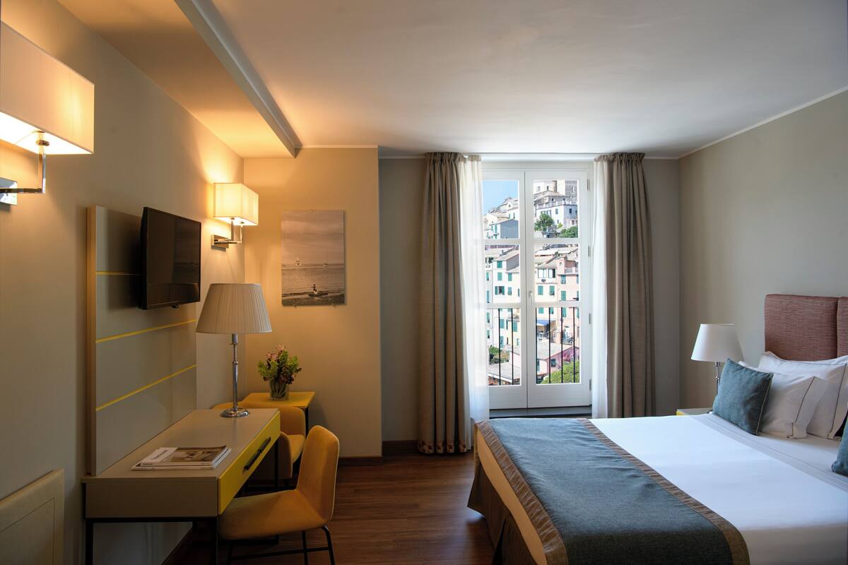 Ein Hotelzimmer mit Bett, Schreibtisch, Stuhl und Fernseher.