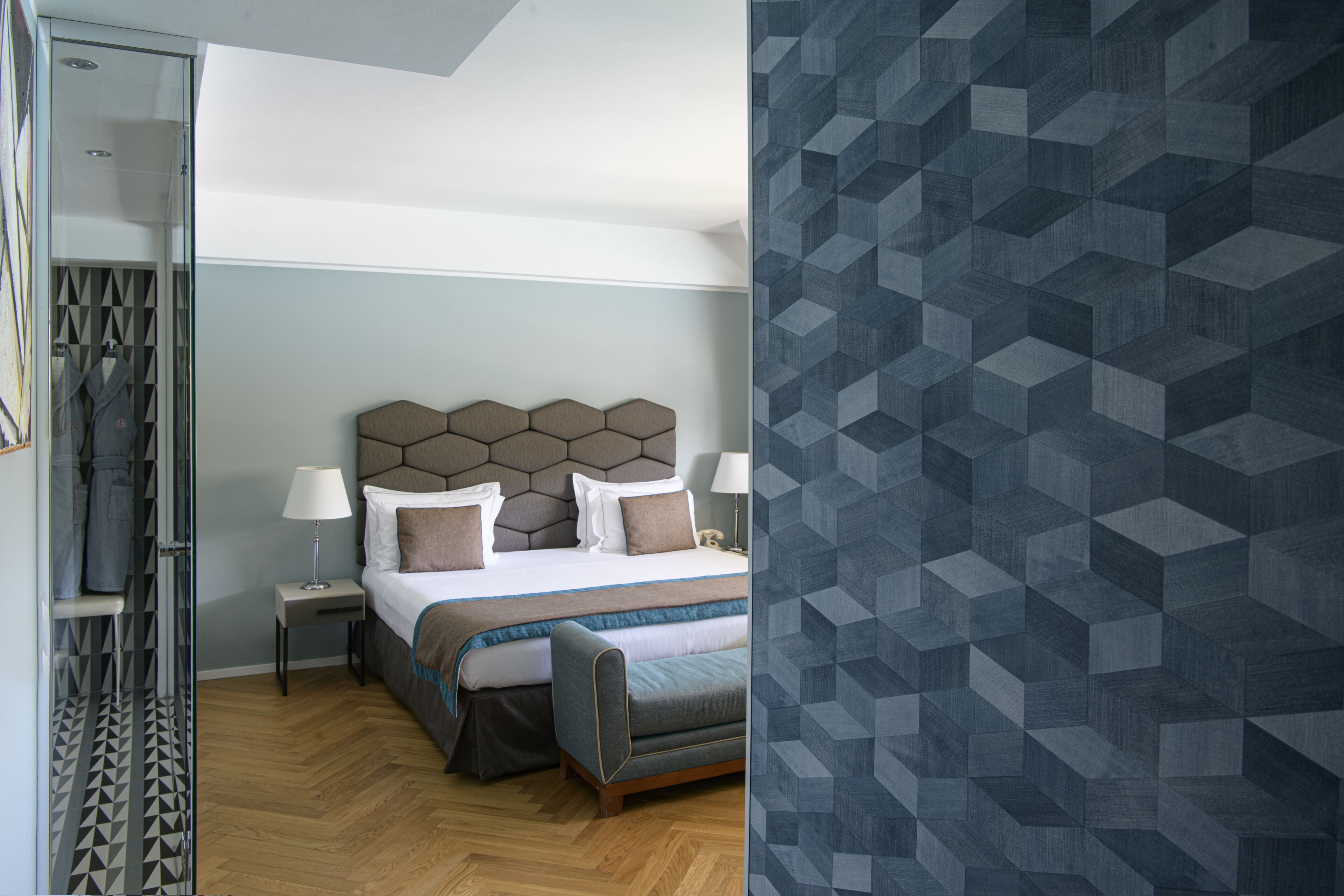 Una camera d'albergo moderna con un letto grande, un comodino e un armadio.