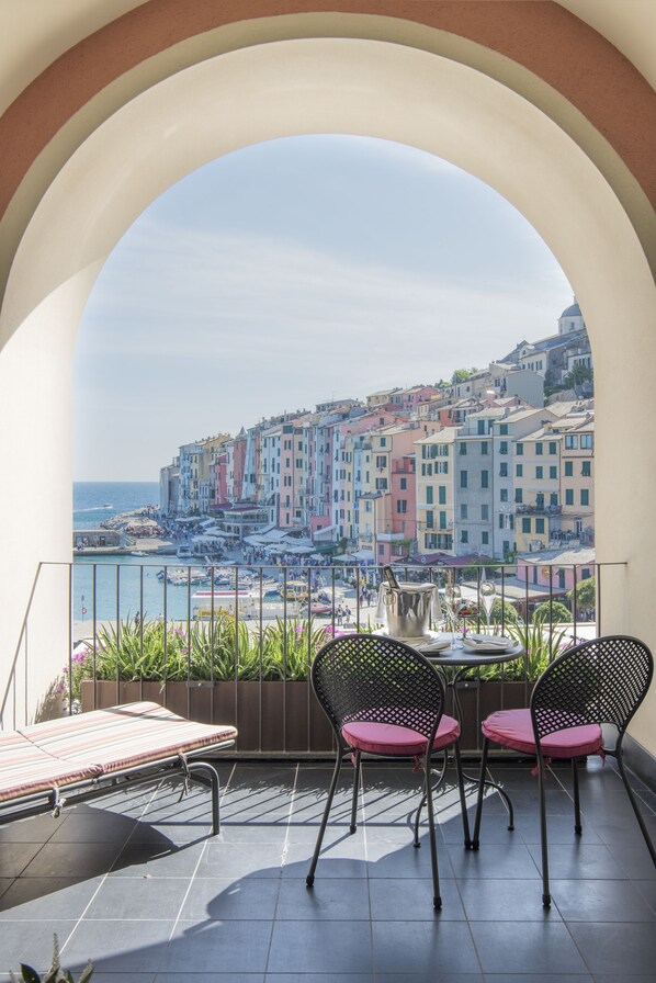 A balcony with a view of colorful buildings and the sea. - Grand Hotel Portovenere (Portovenere)
