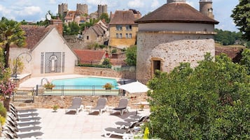 Una piscina al aire libre, sillones reclinables de piscina