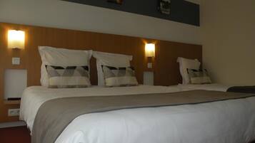 Una camera d'albergo con un letto grande, due comodini e lampade a parete.