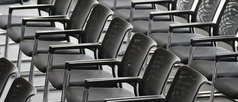 Rows of black chairs with metal frames, arranged in a waiting area.