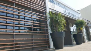 Een modern gebouw met een bord waarop staat: L'espadon LE RESTAURANT.